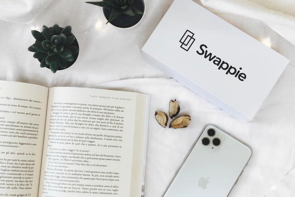Box marchiato Swappie con iPhone e libro. Perché acquistare ricondizionato?